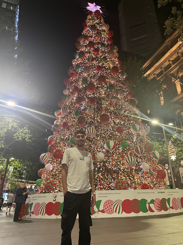 Shane Irani in Australia standing next to a huge Christmas tree in Sydney 