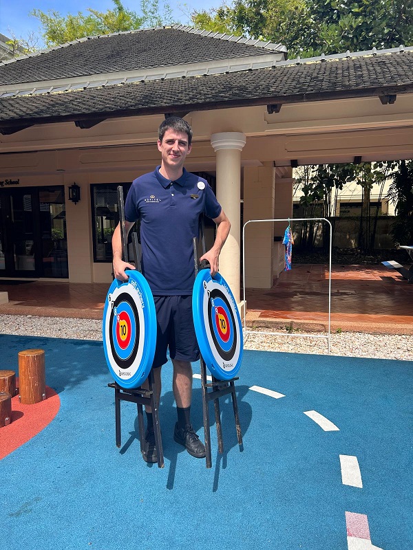 Intern holding archery targets on a hospitality placement in Thailand