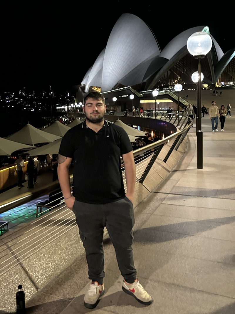 Student standing in front of the Sydney Opera House in Sydney, Australia, in the evening during a Sports placement arranged by Placement Year International